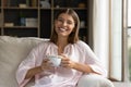 Woman resting on holds tea cup smile look at camera