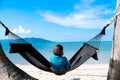 woman resting looking at the sea and mountains She sits in a hammock on a tropical beach. Beautiful tourism concept on the island Royalty Free Stock Photo