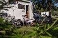 Woman resting near motorhomes in nature. Family vacation travel, holiday trip in motorhome RV, Caravan car Vacation. Royalty Free Stock Photo