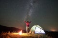 Woman resting at night camping in mountains under starry sky Royalty Free Stock Photo