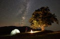 Woman resting at night camping in mountains under starry sky Royalty Free Stock Photo