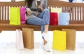 Woman resting in shopping mall, using cellphone and drinking coffee Royalty Free Stock Photo