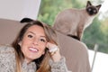 Woman resting in sofa with little kitten cat siamese in home couch Royalty Free Stock Photo