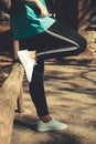 A woman resting in a wooden fence wearing sport clothes