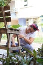 A woman restores and improves an old wooden chair in her home