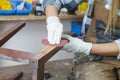 woman restoring furniture using sand paper