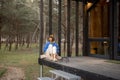 Woman rests near wooden cottage in nature Royalty Free Stock Photo