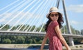 WOMAN rests on the river in the city. Background bridge