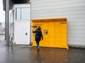Woman retrieving parcel from Amazon locker snowy day