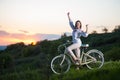 Woman with retro bike on the hill in the evening Royalty Free Stock Photo