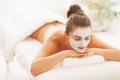 Woman with revitalising mask on face laying on massage table Royalty Free Stock Photo