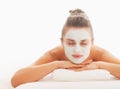 Woman with revitalising mask on face laying on massage table Royalty Free Stock Photo