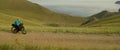 The woman is ride on top of a hill with the mountain lake in background the picturesque valley. The pretty girl travels Royalty Free Stock Photo