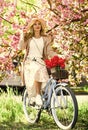 Woman ride vintage bicycle. Romantic girl and sakura blossom. Spring season. Cherry tree blooming. Self Guided Cycling