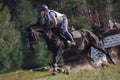 Woman rider and black sport horse galloping energetically during eventing competition Royalty Free Stock Photo