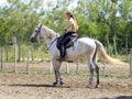 Woman rider mounted on white horse