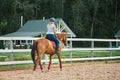 Woman rider rides horse on ranch