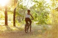 A woman rides a bicycle along a path in the forest at dawn. Cardio and healthy lifestyle Royalty Free Stock Photo