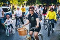 A woman rides a bicycle behind the participants of a charity bicycle race in support of Ukraine