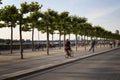 Woman rides bicycle and a boy rides skateboard Royalty Free Stock Photo