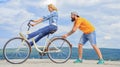 Woman rides bicycle sky background. Girl cycling while man support her. Man helps keep balance ride bike. Cycling Royalty Free Stock Photo