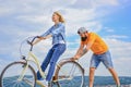 Woman rides bicycle sky background. How to learn to ride bike as an adult. Girl cycling while boyfriend support her