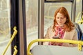 A woman rides a bus and looks at the route on her phone Royalty Free Stock Photo
