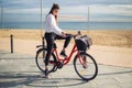 Woman riding bicycle along beach sand at summer time Royalty Free Stock Photo