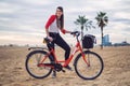 Woman riding bicycle along beach sand at summer time Royalty Free Stock Photo