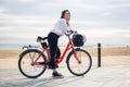 Woman riding bicycle along beach sand at summer time Royalty Free Stock Photo