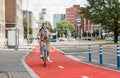 woman riding bicycle along red bike lane in city Royalty Free Stock Photo