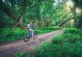Woman riding a bicycle in forest in spring at sunset Royalty Free Stock Photo