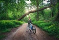 Woman riding a bicycle in forest in spring at sunset Royalty Free Stock Photo