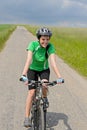 Woman riding bike on cycling path meadow