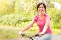 Woman riding bike on forest meadow.