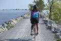 woman riding bike on gravel trail (young south asian, indian rider on bicycle trail) burlington vermont causeway path
