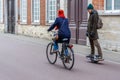 A woman riding bike and a man riding one wheel hoverboard on the road