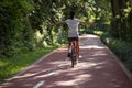 Woman riding a bike on sunny park trail Royalty Free Stock Photo