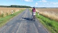 woman riding her bike on lonesome rural road