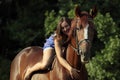 Woman riding horse bareback through forest