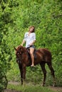 Woman riding horseback through forest Royalty Free Stock Photo