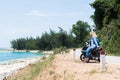 Woman riding motorcycle along the sea on the road to Hai Van pass, Vietnam