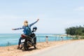 Woman riding motorcycle along the sea on the road to Hai Van pass, Vietnam