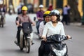 Woman riding motorcycle and chat with passenger in the back seat on the road in Hanoi, Vietnam