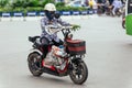 Woman riding motorcycle with her belongings on the road in Hanoi, Vietnam