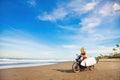 Woman riding a motorcycle with the surfboard