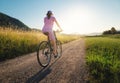 Woman is riding a mountain bike on gravel road at sunset Royalty Free Stock Photo