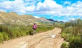 Woman riding a mountain bike by a muddy path of dirt Royalty Free Stock Photo