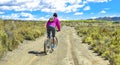 Woman riding a mountain bike by a muddy path of dirt