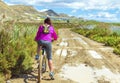 Woman riding a mountain bike by a muddy path of dirt